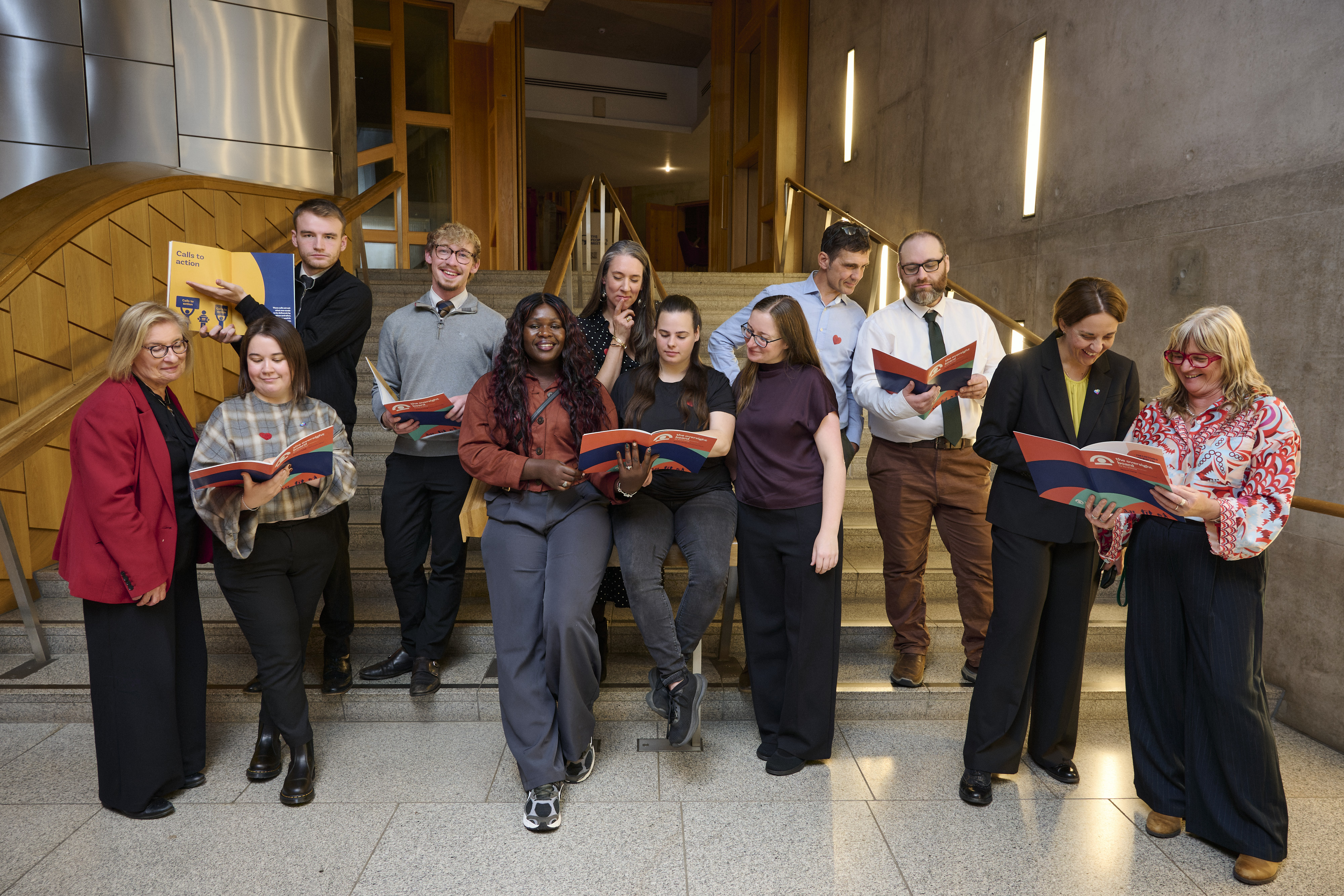 Members of the Oversight Board holding copies of their latest report.
